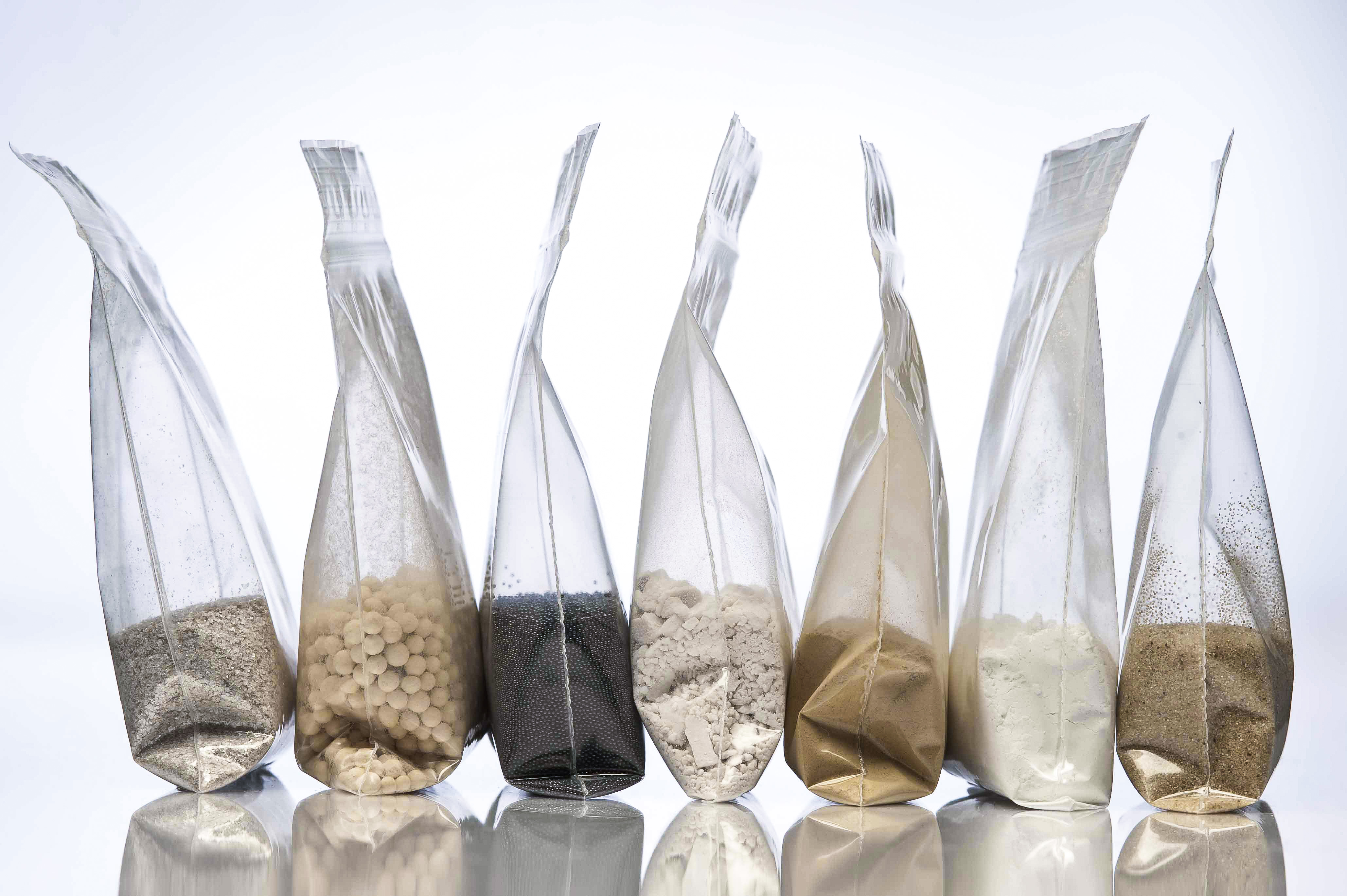 Material samples from IBU-tec production or development in bags: quartz, activated carbon and charcoal and others